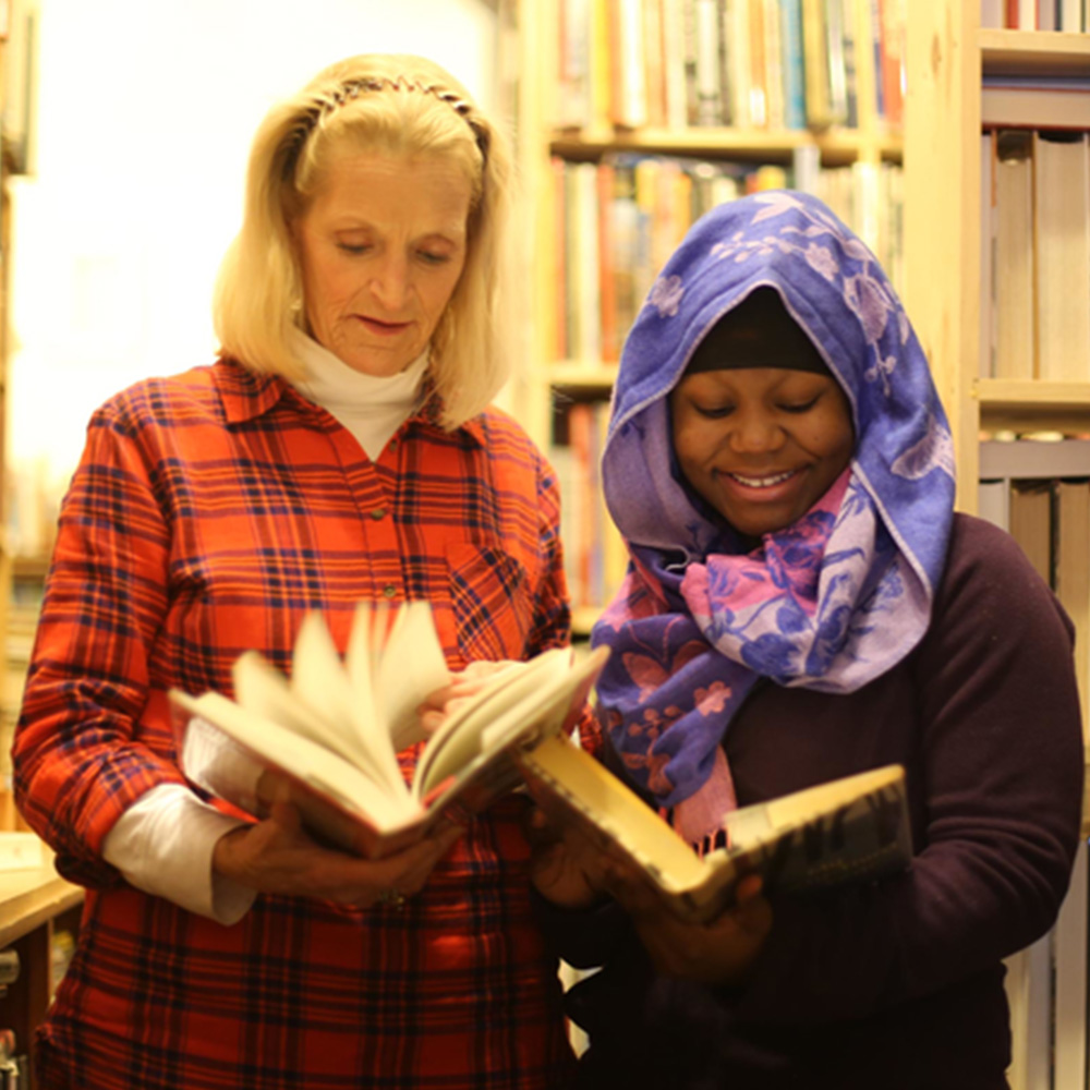 Two women standing looking at books
