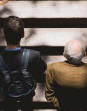 An older and younger man, photographed from above, climbing a staircase