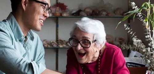 A young man and older woman smiling widely